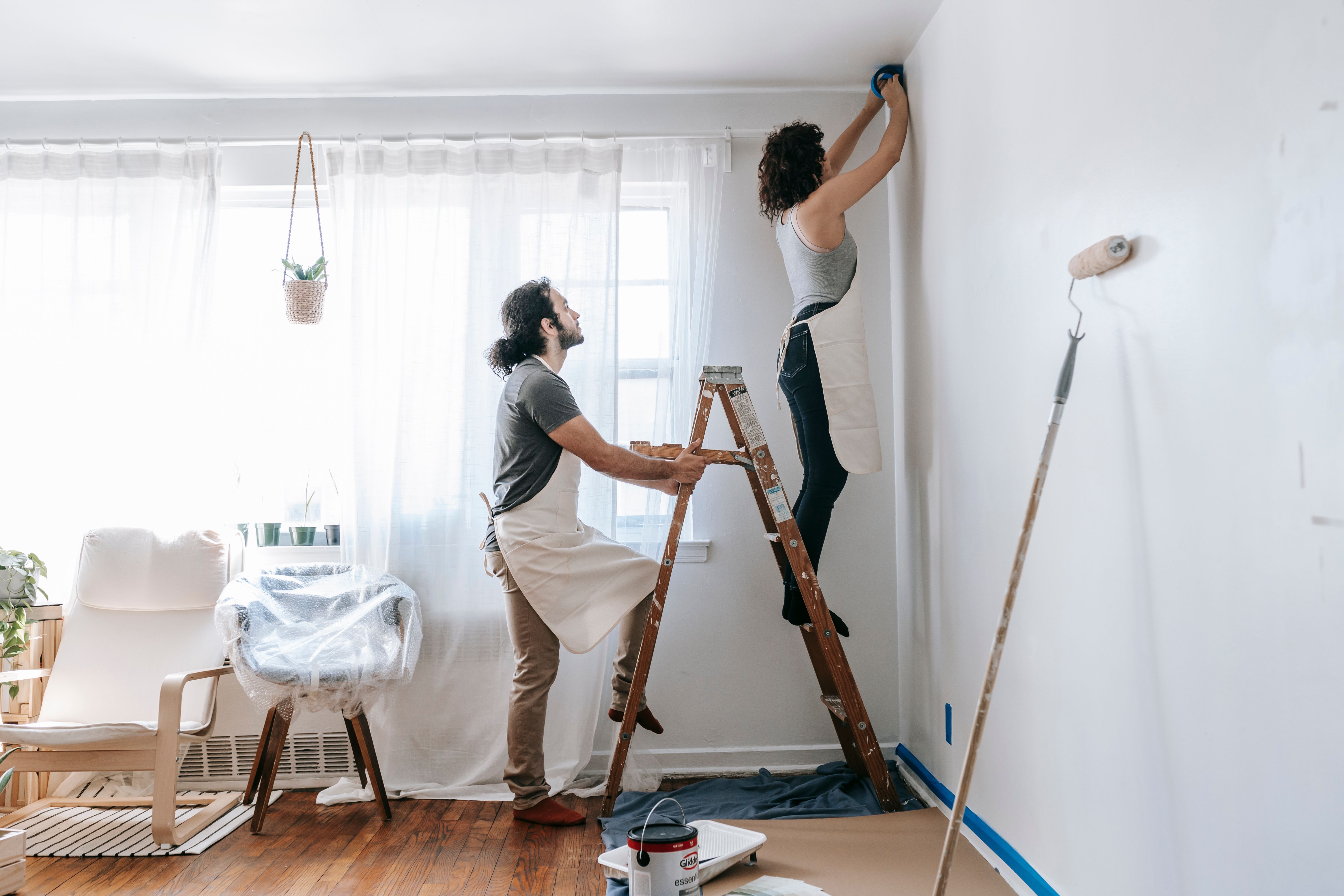 Owner Builder Permit QLD: Requirements, Costs and How to Apply 3 Couple renovating their home with one person steadying a ladder indoors
