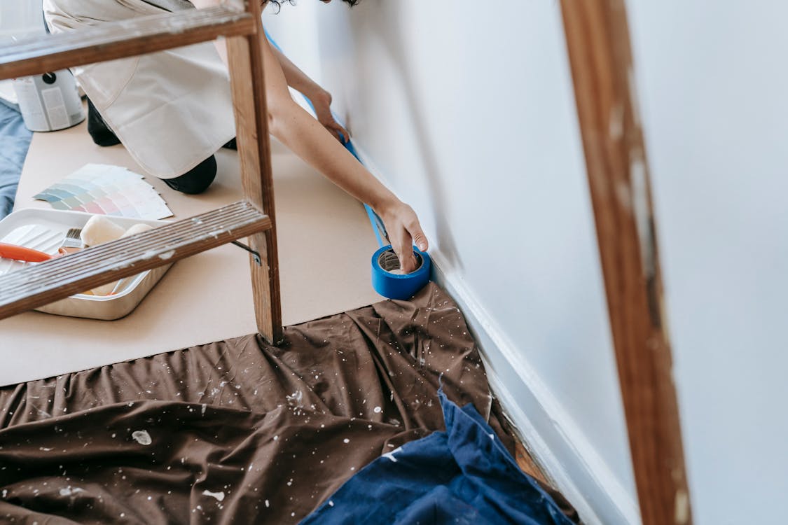 Free Crop Photo Of Person Putting Tape On Wall Stock Photo