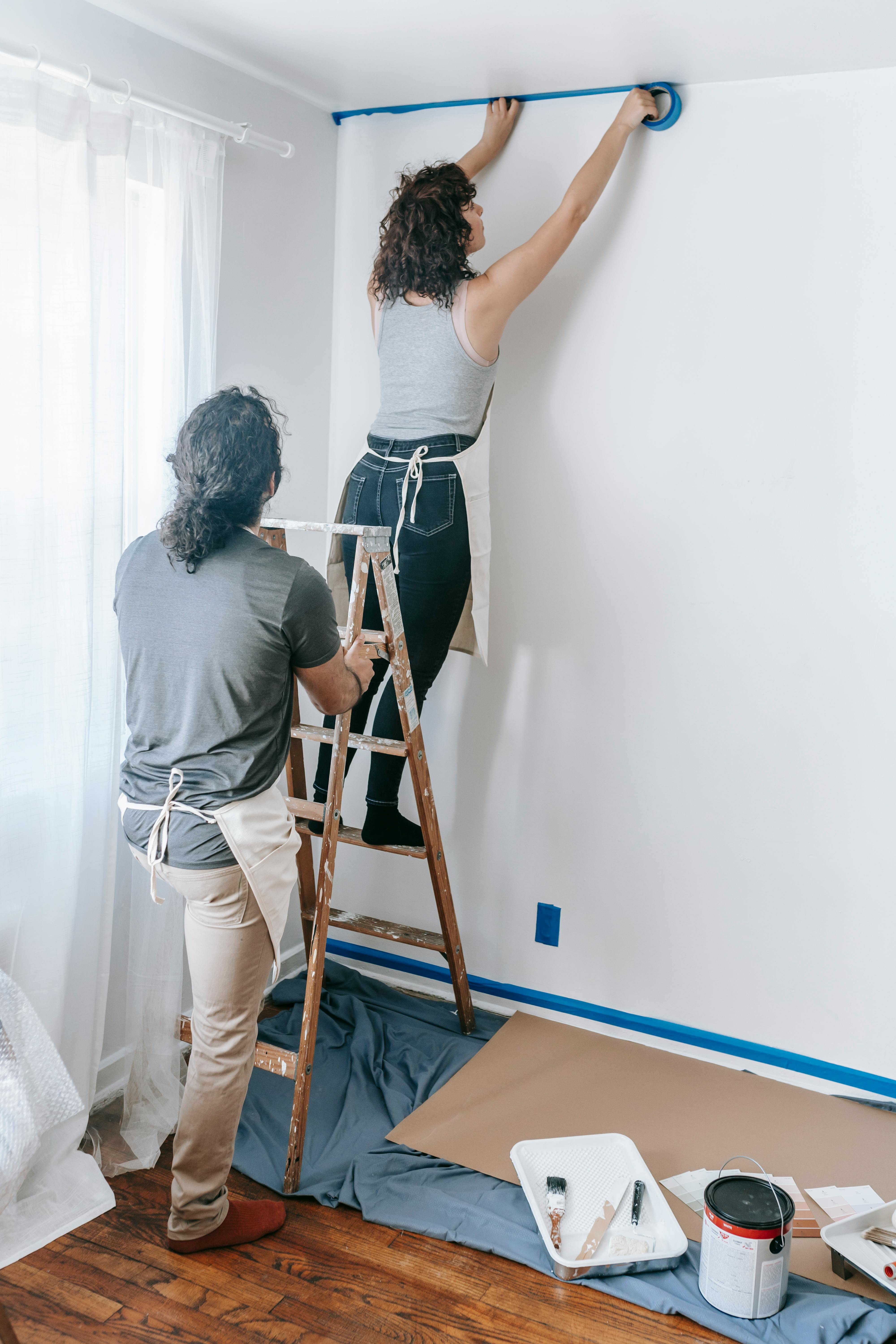 woman putting tape on the wall