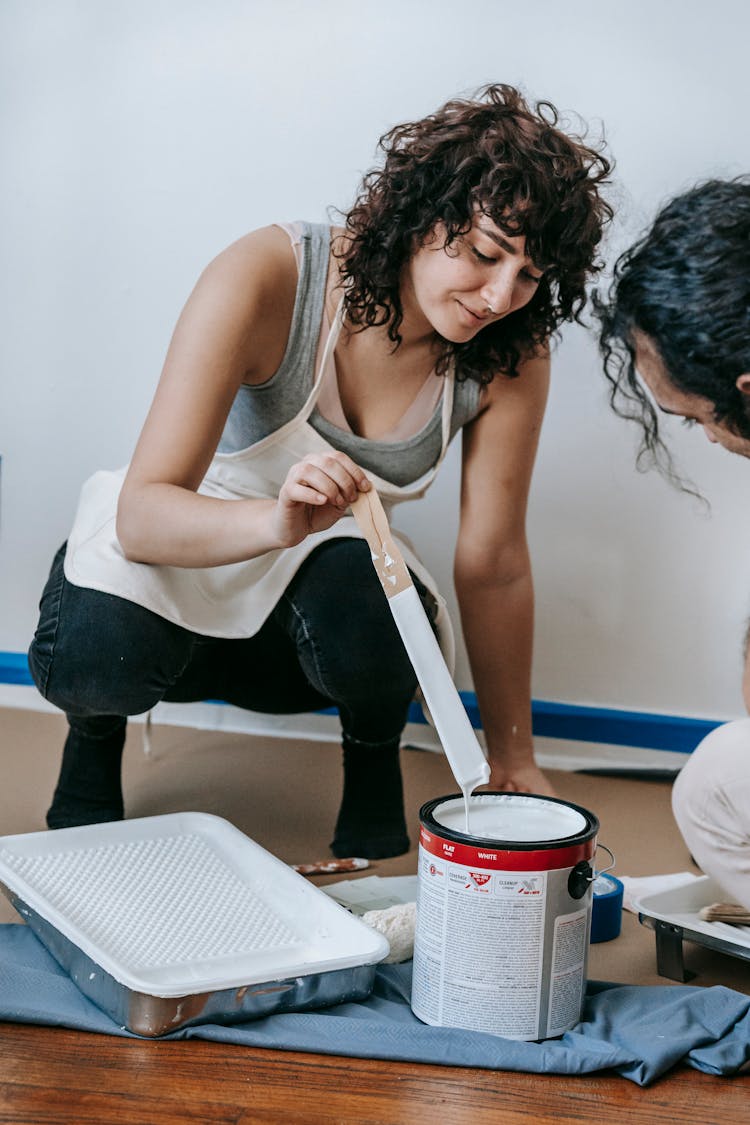 Woman Mixing A Paint With Stick