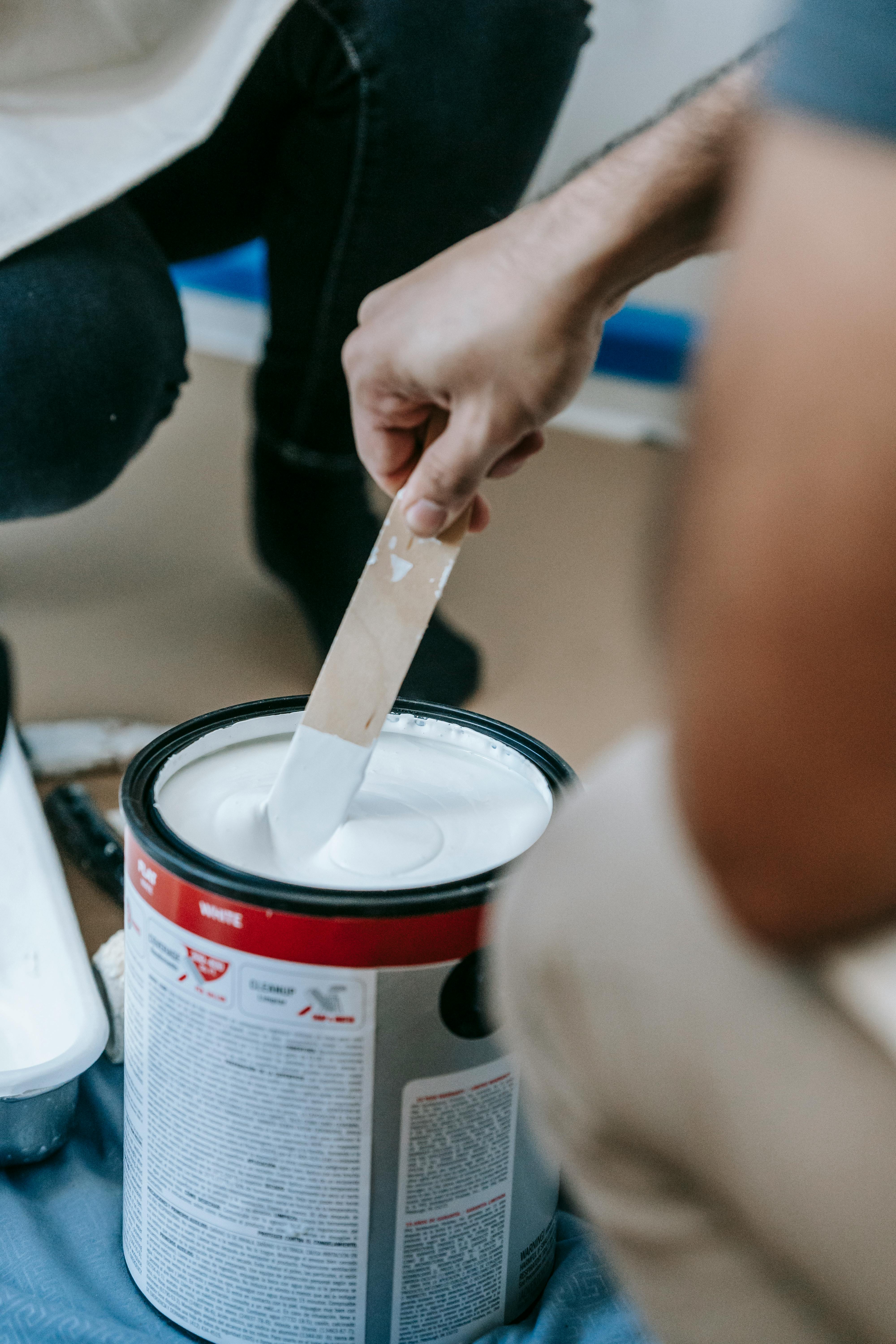 person mixing a can of paint