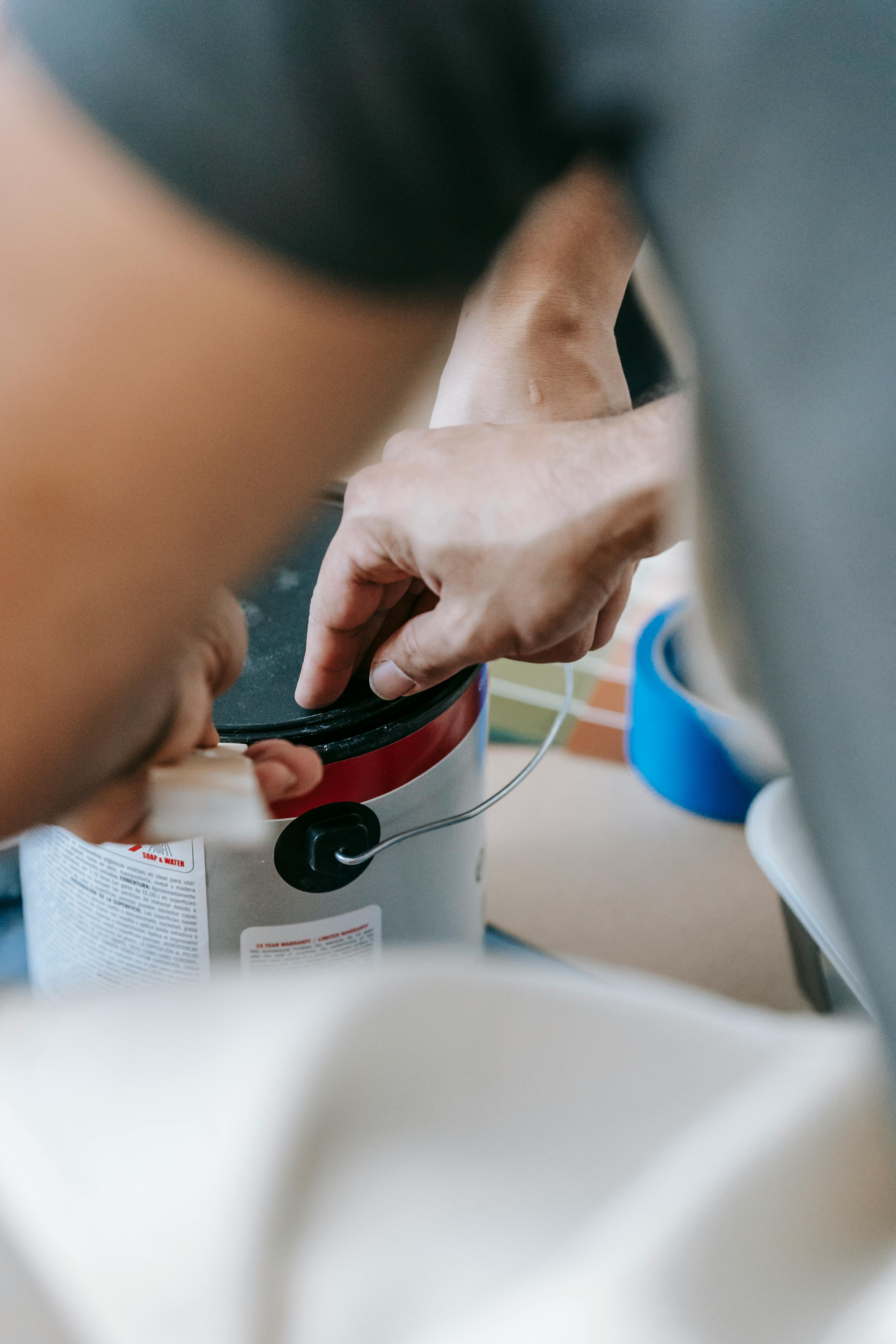 a man opening a can of paint