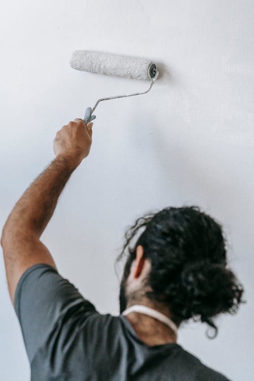 Free Man Painting A Wall Stock Photo