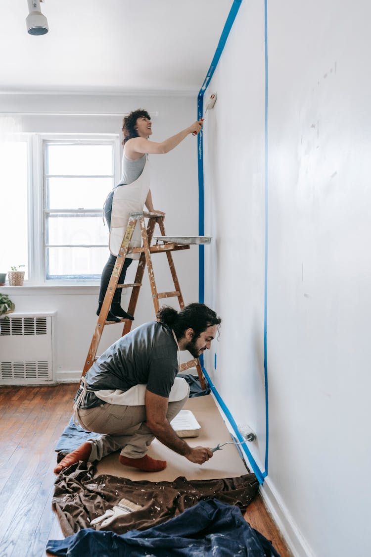 A Couple Painting The Wall 