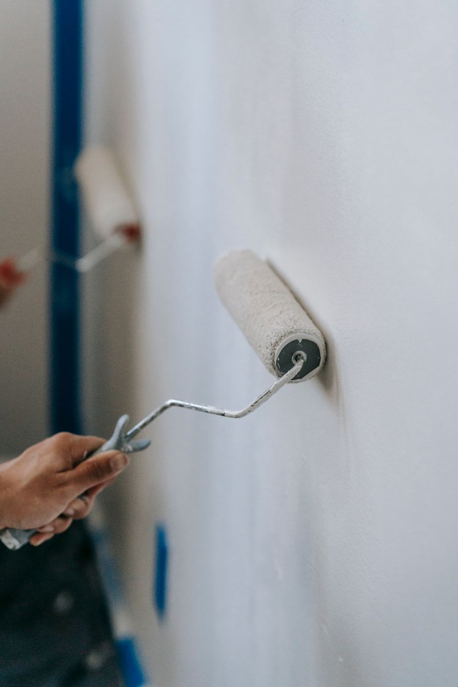 Rolling a fresh coat of paint onto an interior wall