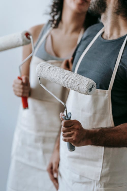 Crop Photo Of Couple Holding Paint Rollers