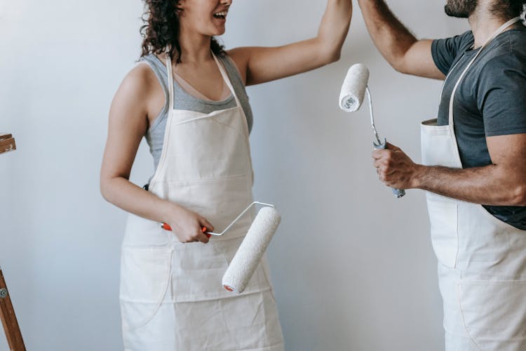 Crop Photo Of Couple Holding Paint Rollers