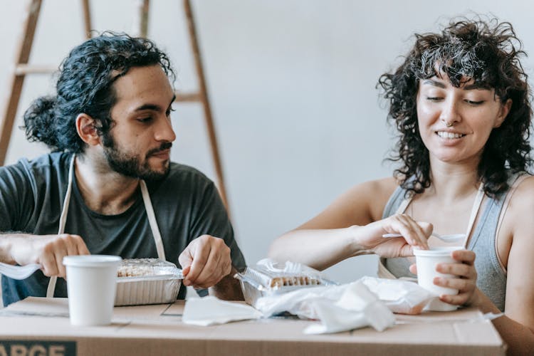 Couple Eating With Food On Top Of A Box