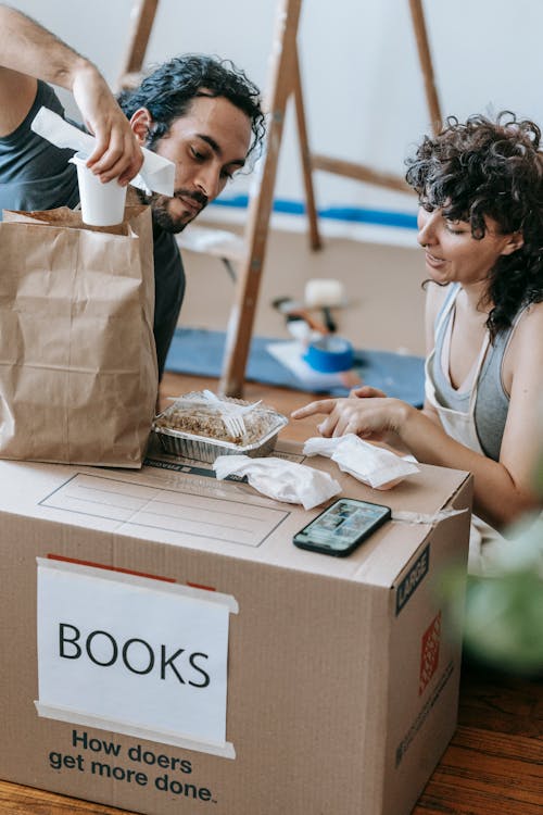 A Couple With Food On A Box Of Books