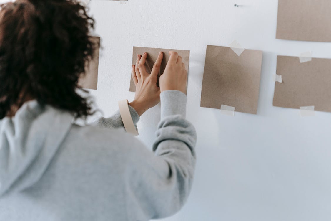 Woman Putting A Cardboard On Wall