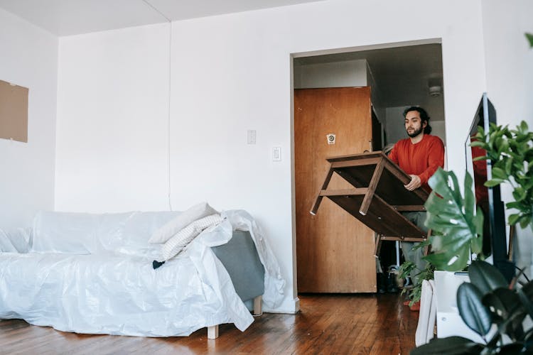 Man Carrying A Wooden Table