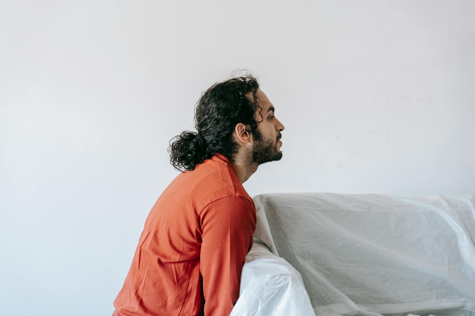Young man in casual attire preparing furniture for moving inside his home.
