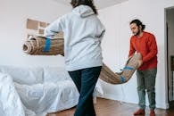 Couple Holding A Rolled Carpet