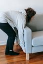 Woman Lifting A Couch