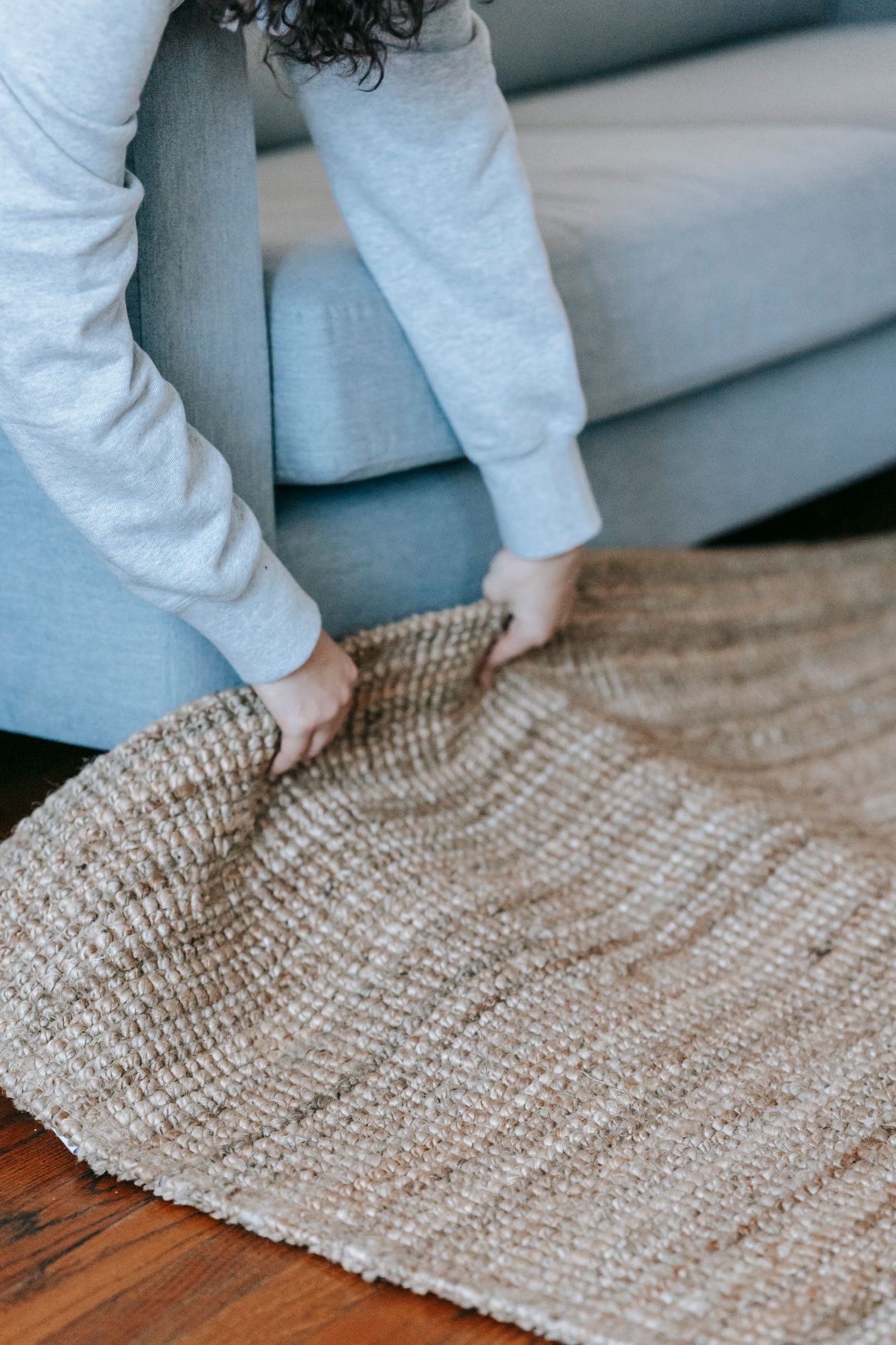 Person lifting the edge of a woven rug