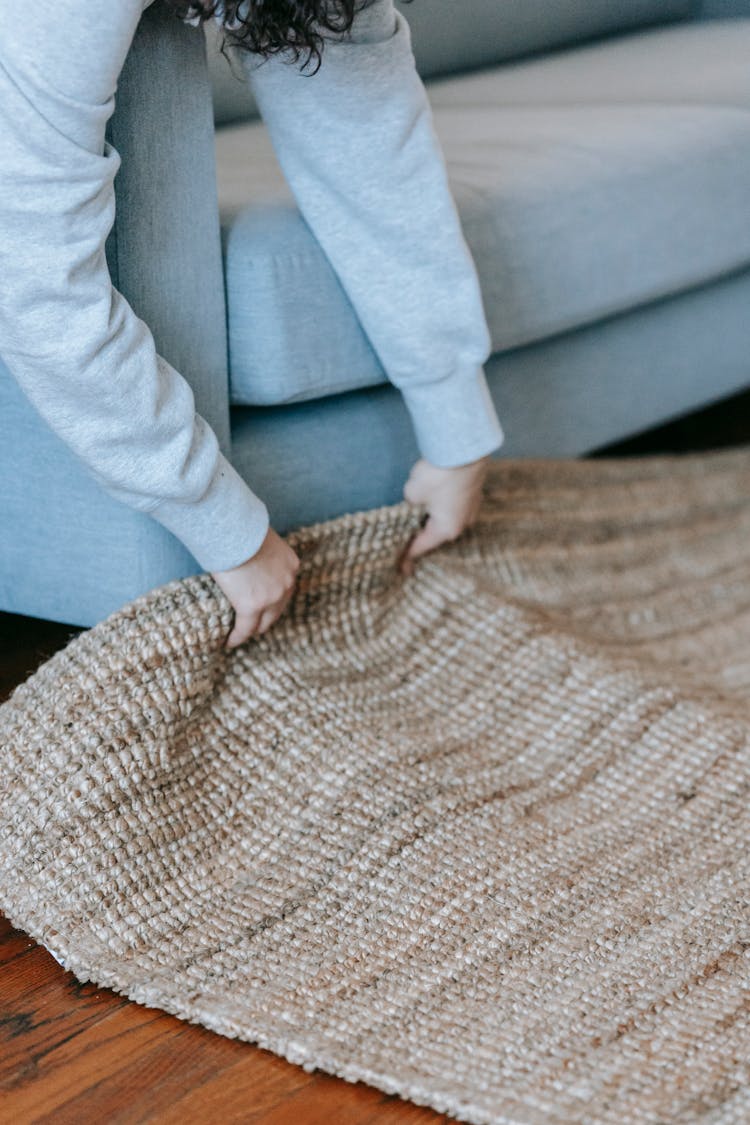 Person Lifting Up A Carpet