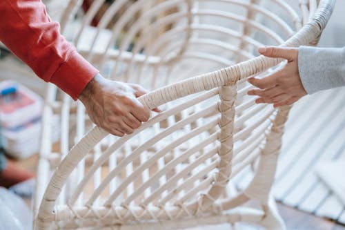 Two People Holding A White Chair