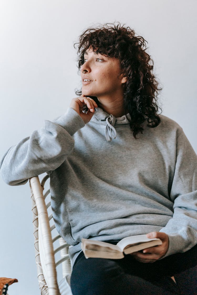 Woman In Gray Sweater Sitting On White Chair