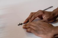 Close-Up Photo of a Person's Hands Near a Rosary