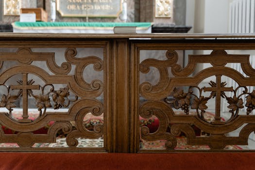 Elegant wooden altar rail featuring intricate Christian cross design in a church setting.