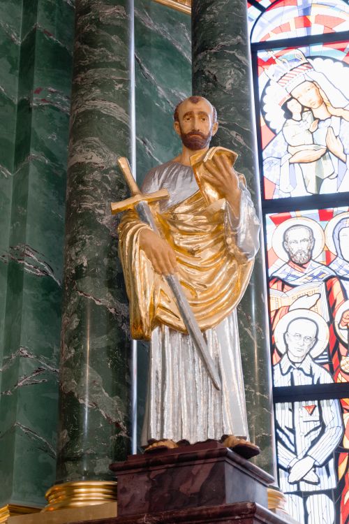 Free A detailed statue in a church with vibrant stained glass background. Stock Photo