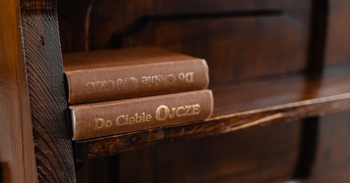 A cozy rustic wooden shelf displaying vintage books with gold embossed titles.