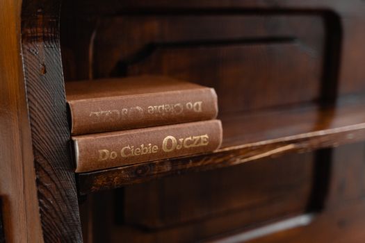 A cozy rustic wooden shelf displaying vintage books with gold embossed titles.
