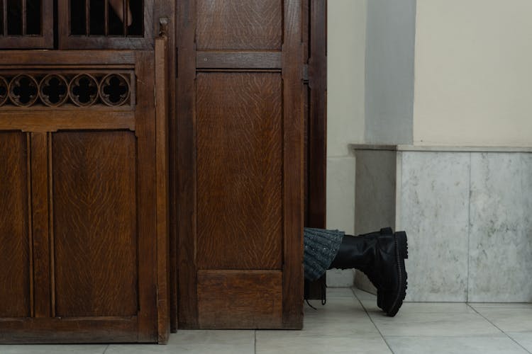 Feet Of A Person Kneeling In A Confessional