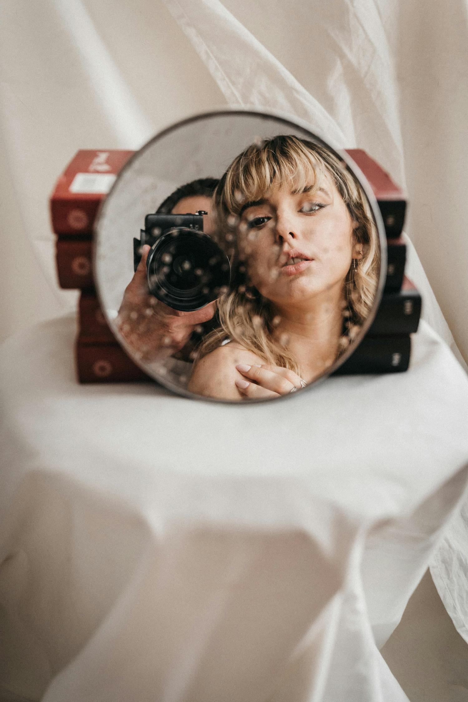 Girlfriends with photo camera against mirror on fabric · Free Stock Photo