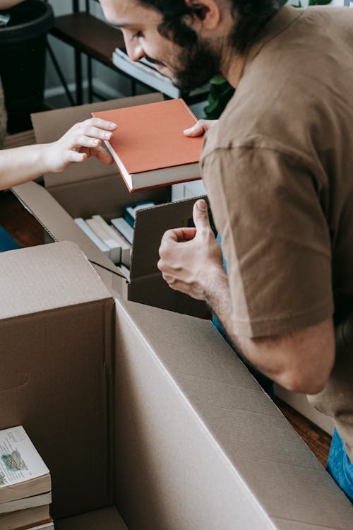 Free Man Packing Books In A Box Stock Photo