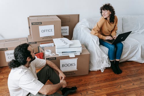 Couple Sitting Beside Packed Boxes