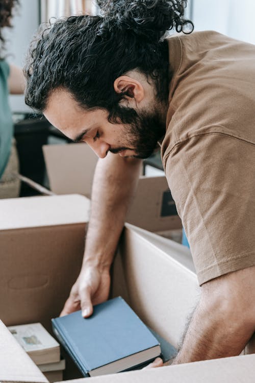 Free Man Putting Books In A Box Stock Photo