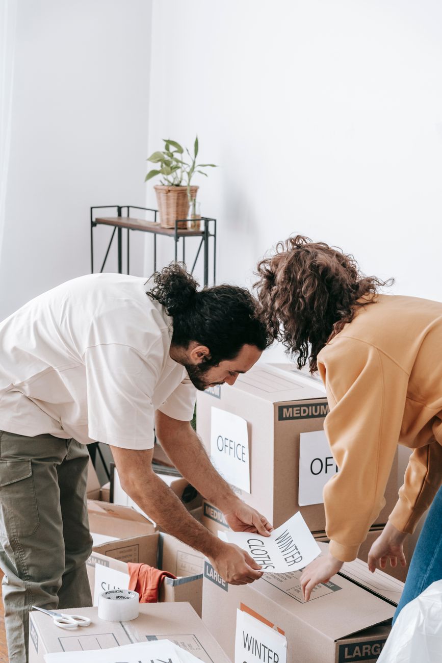 Couple Placing Printed Papers On Boxes · Free Stock Photo