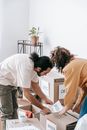 Couple Placing Printed Papers On Boxes