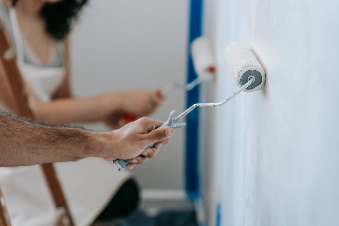 Two People Painting The Wall · Free Stock Photo