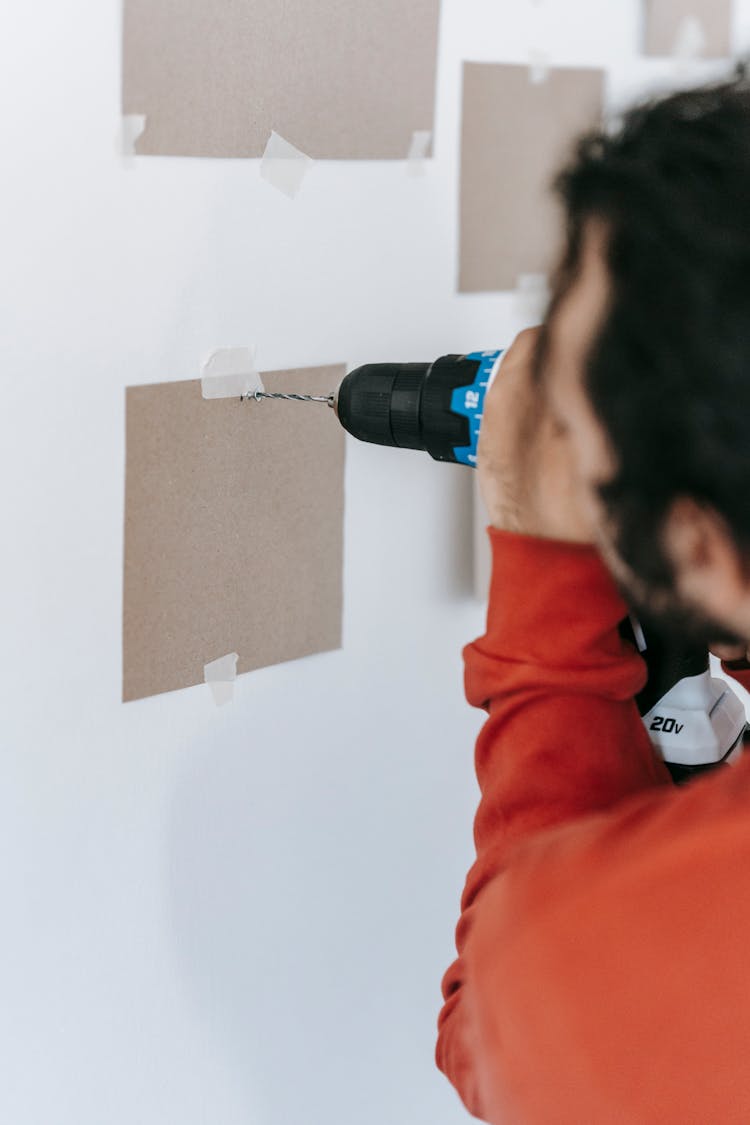 Man Drilling A Wall