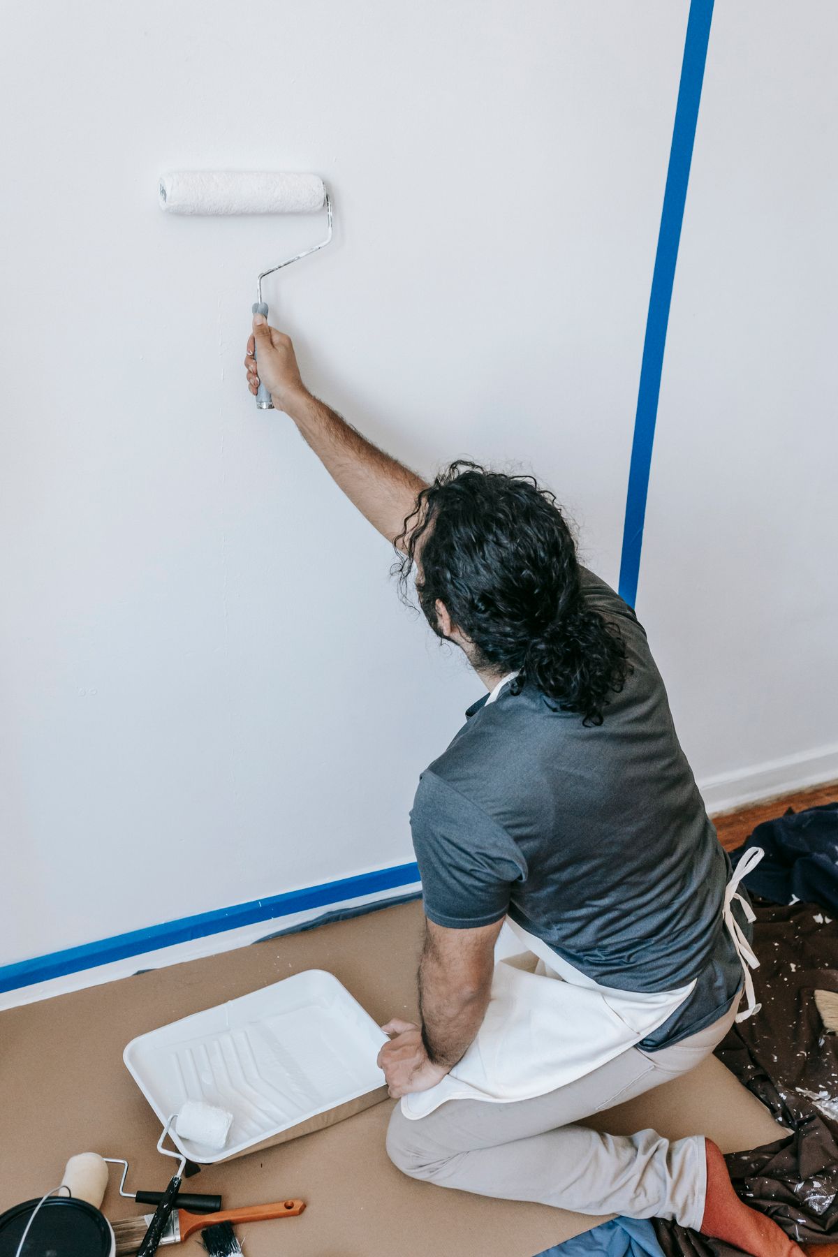 Pintor aplicando pintura blanca en una pared