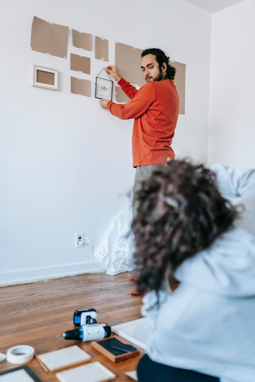 Couple Removing And Packing The Picture Frames