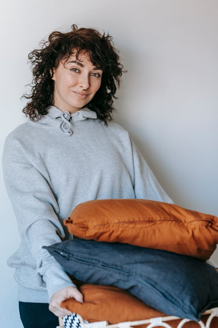 Woman Carrying A Basket Of Throw Pillows