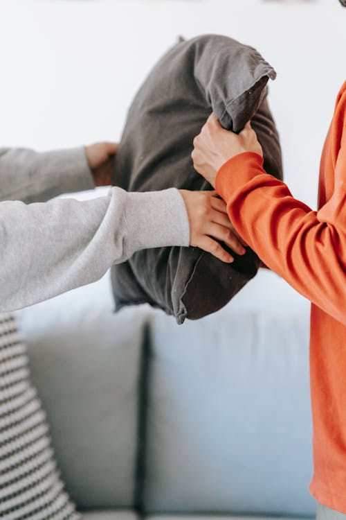 Two People Holding A Throw Pillow