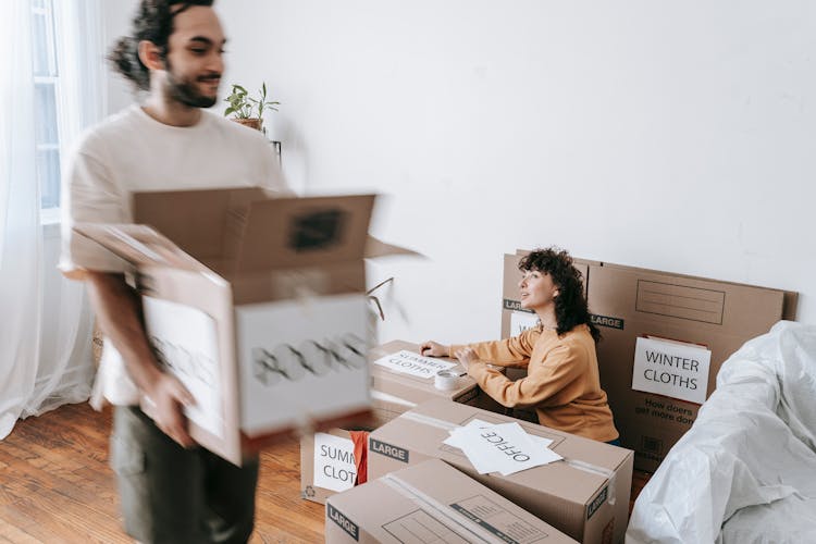 Couple Packing Things In Boxes