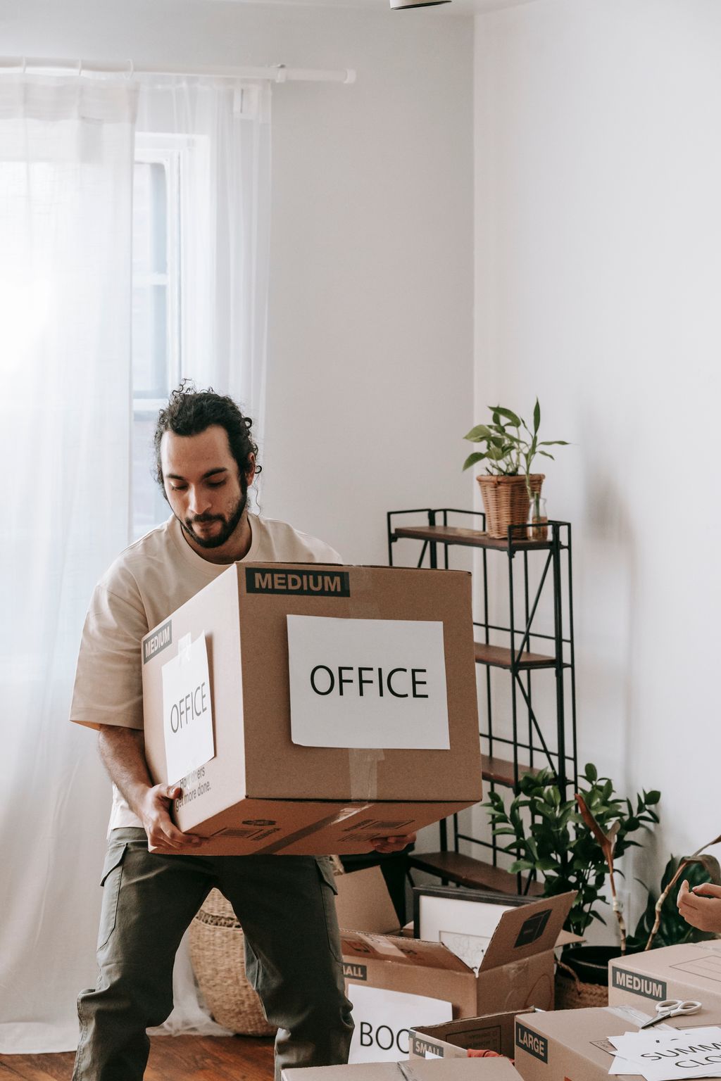 Homme portant un carton de déménagement de bureau