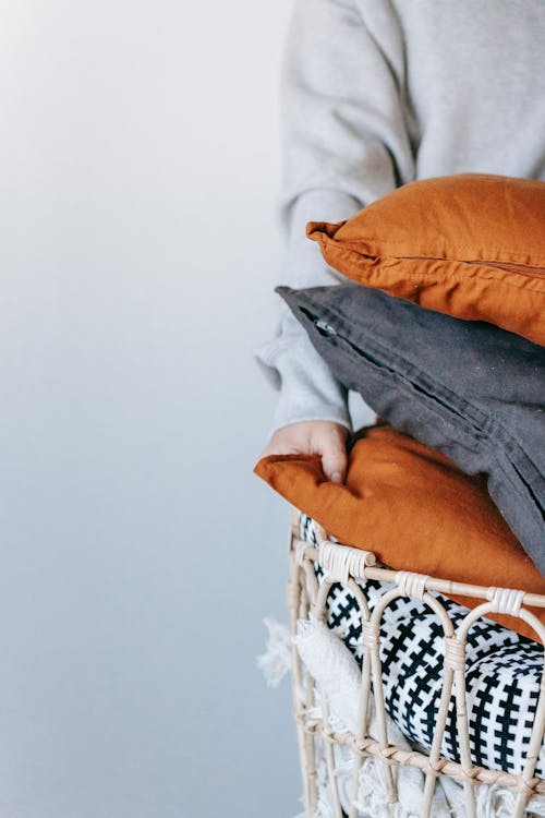 Person Carrying A Basket Of Throw Pillows 