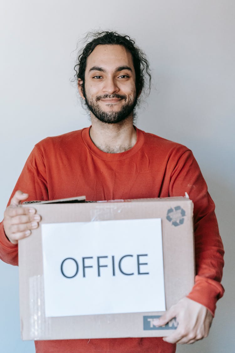 Man Carrying A Box With Office Sign