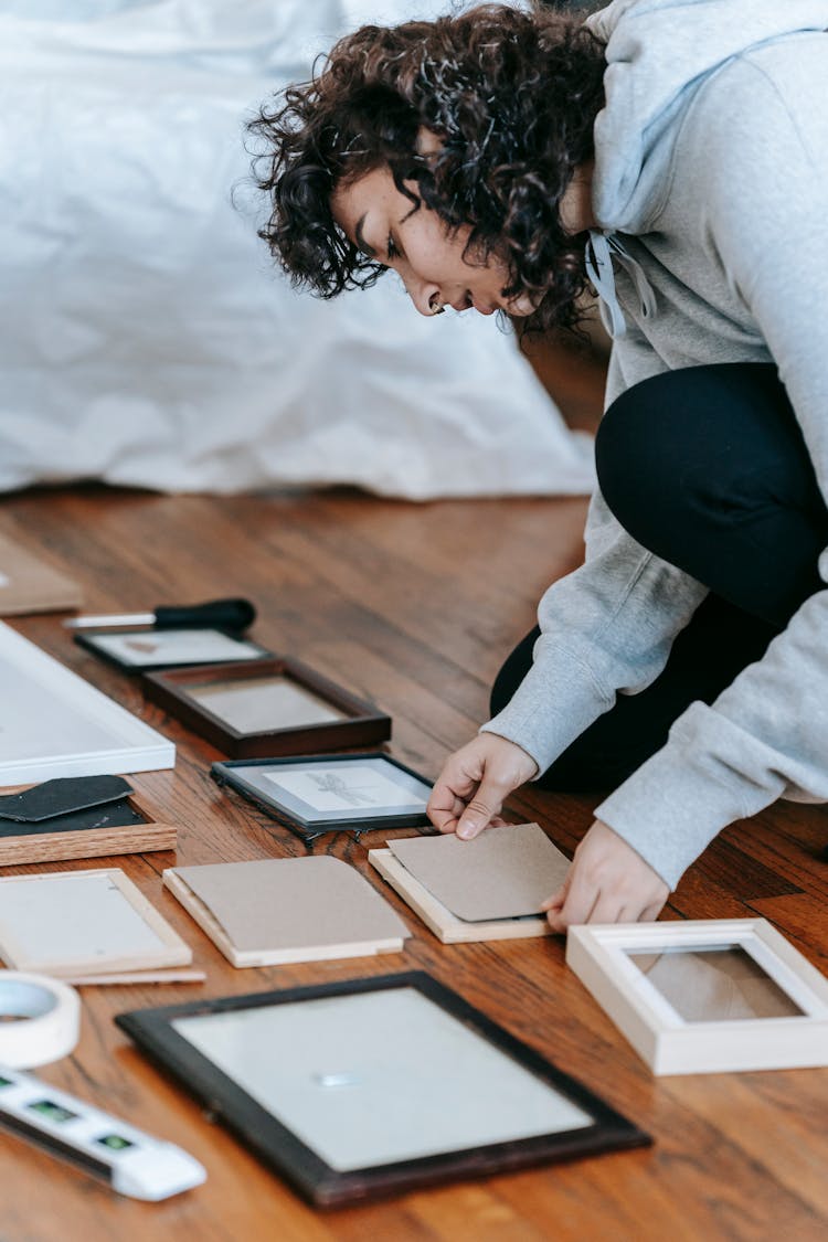 Woman Fixing Picture Frames