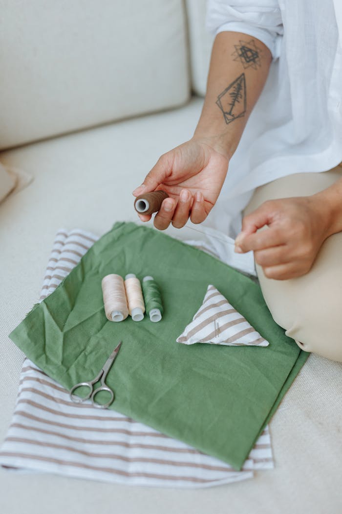 Hands at work with needle and thread, the considered act of construction