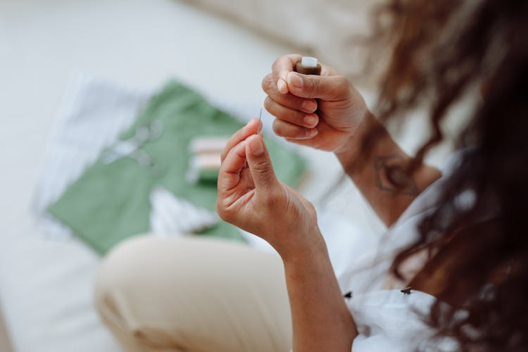 A Person Holding A Needle And A Thread