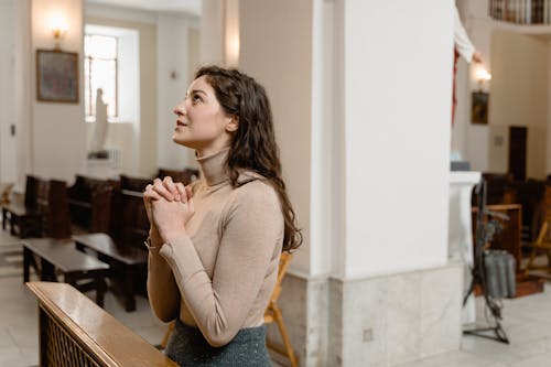 Free Woman in a Brown Long Sleeve Shirt Praying Stock Photo