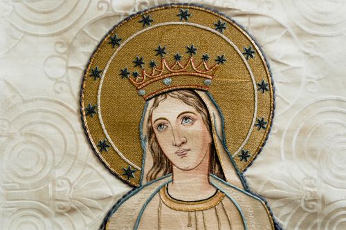 Free Beautifully detailed religious embroidery depicting a holy figure adorned in gold and stars. Stock Photo