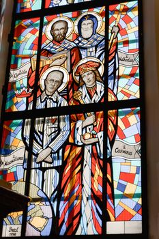 Colorful stained glass window depicting saints with intricate designs.